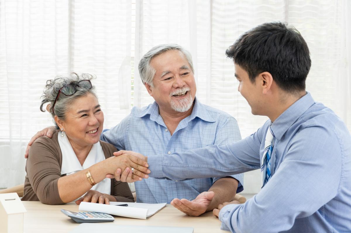 A couple thanking their loan specialist after closing on their reverse mortgage.
